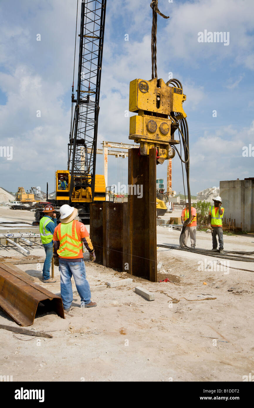 l-equipe-de-construction-utilise-un-equipement-hydraulique-de-battage-de-pieux-pour-enfoncer-des-palplanches-d-acier-sur-le-chantier-b1ddt2.jpg