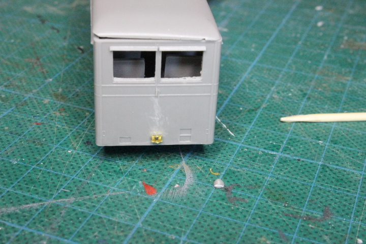 le support de phare est le petit bout de laiton, à droite de la tache de peinture grise et au dessus du phare en résine